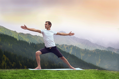 yoga man fitnes in mountain, warrior pose