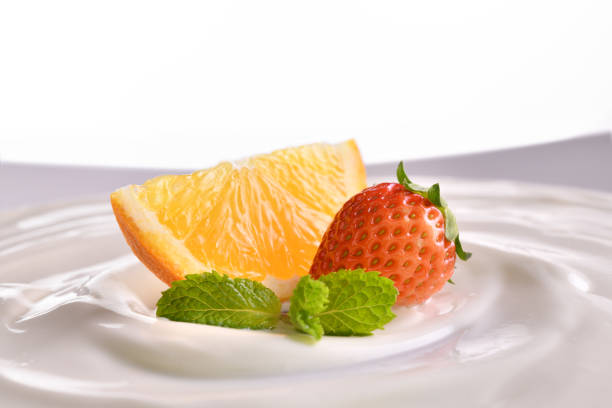 Plain yogurt with fresh fruits on top in bowl isolated on white background