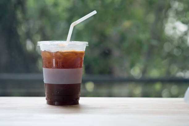 istock Iced americano coffee on wood table with nature background 1145402714