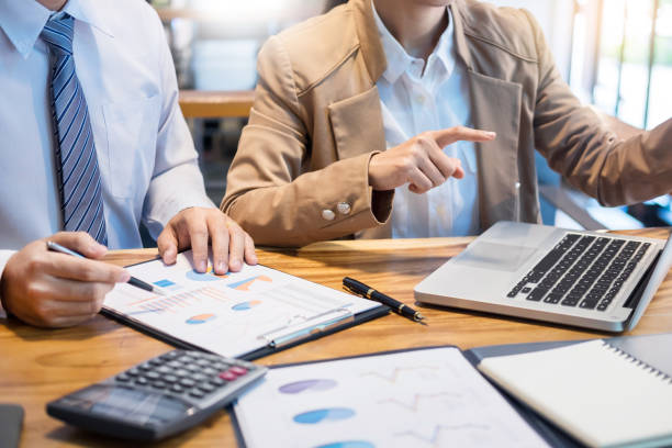 istock Midsection Of Colleagues Working Over Graph In Office 1145403086