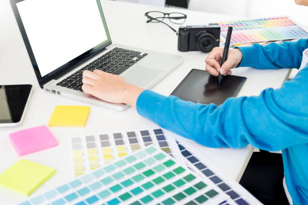 istock Midsection Of Woman Using Laptop And Graphics Tablet On Office Desk 1145405046
