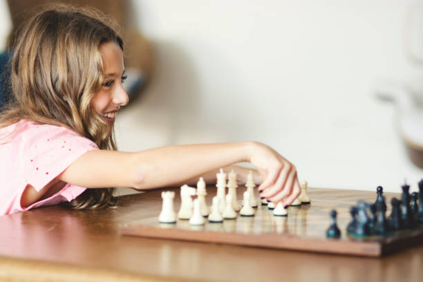 schönes und kluges mädchen, das schach spielt - concentration chess playing playful stock-fotos und bilder