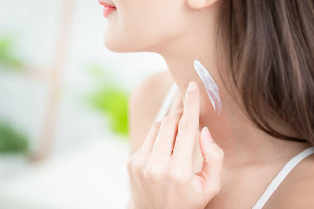 woman applying cream on neck young beauty woman applying cream or sunscreen on her neck neck photos stock pictures, royalty-free photos & images