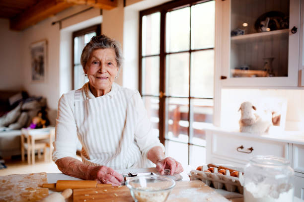 istock Elderly woman making cakes in a kitchen at home. Copy space. 1145415338