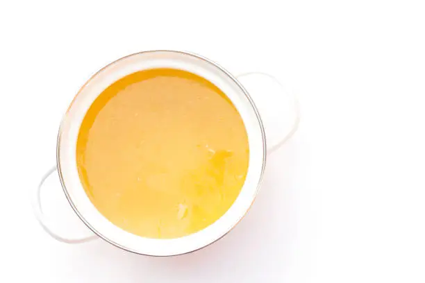 Bowl of chicken broth isolated on white background.