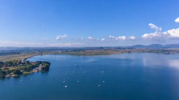 Flying aerial photo of full dam waters moored boats a scenic holiday landscape