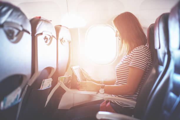 istock Female passenger of airplane working on tablet pc during fly 1145420540