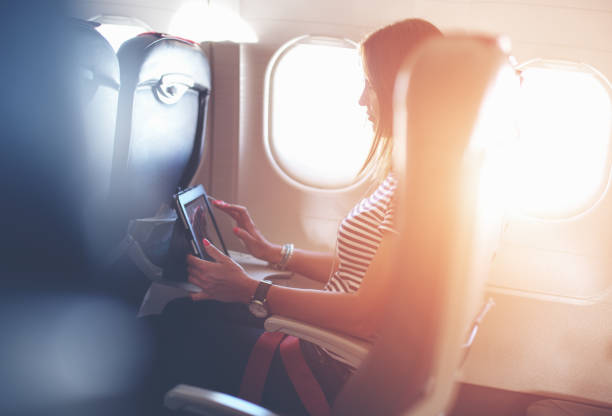 istock Female passenger of airplane working on tablet pc during fly 1145420547