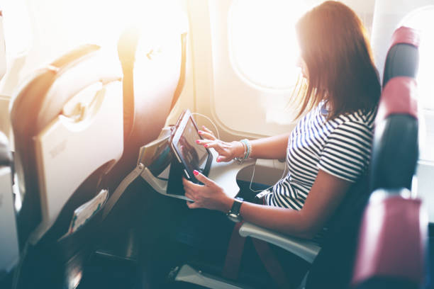 istock Female passenger of airplane working on tablet pc during fly 1145420548