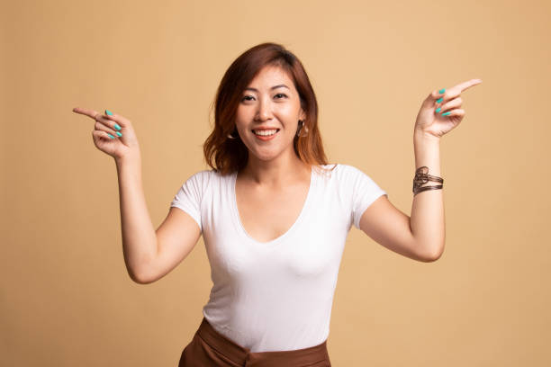 istock Young Asian woman point to left and right. 1145422427