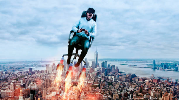 Concept of virtual reality with man wearing 3D-glasses and flying through the air Man sits in office chair with rockets attached. He wears virtual reality glasses and holds on to a game controller. He flys through the air and screams because of the immersive gaming experience. New York City is in the background. game controller photos stock pictures, royalty-free photos & images