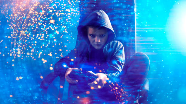 Kid with hooded shirt plays video game and holds game controller in his hands