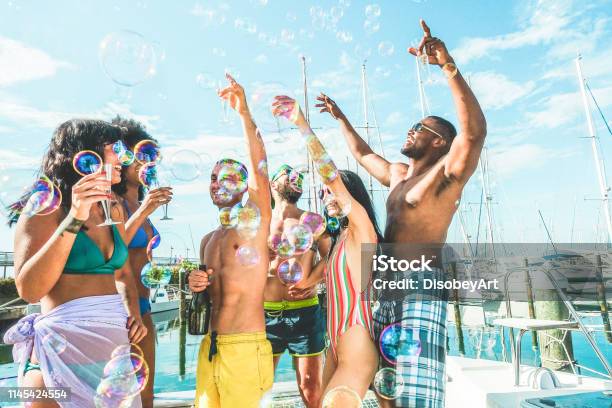 Happy Vrienden Drinken Champagne In De Zomer Boat Partyjonge Mensen Die Plezier Vieren En Dansenjeugd Lifestyle Exclusieve Fest En Vakantieconceptbelangrijkste Focus Op Het Centrum Jongens Gezichten Stockfoto en meer beelden van Feest