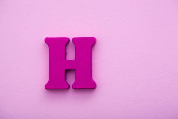 istock Wooden letter H on pink background. 1145424682