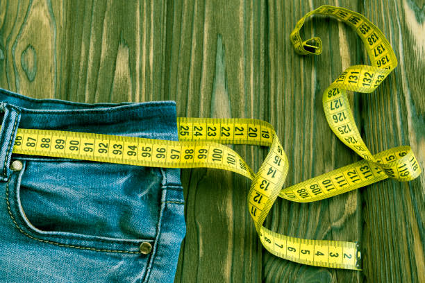 istock Jeans, centimeter on the background of a wooden table. 1145428873