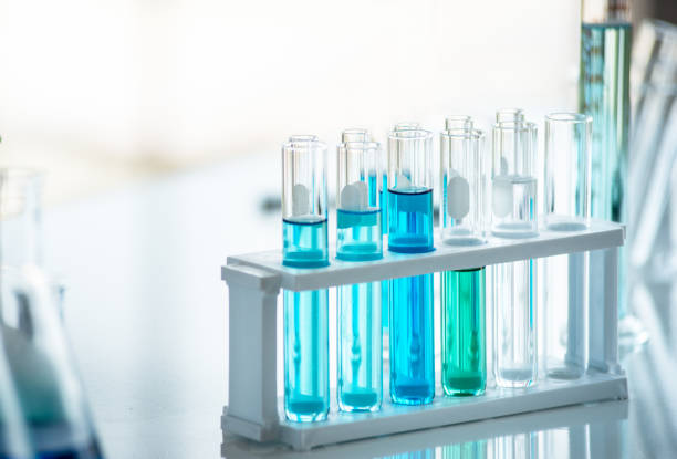 Preparación de equipos de laboratorio como cristalería, tubo con líquido azul en la mesa blanca. El experimento químico en la investigación científica - foto de stock