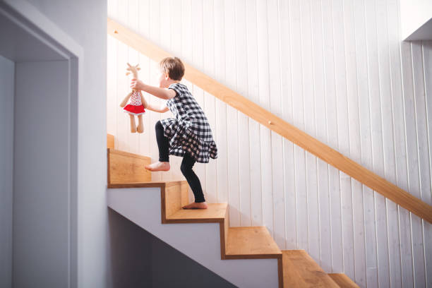 istock A small child with a soft toy walking up the stairs. 1145432646