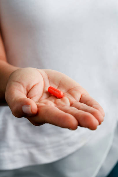 istock Single white aspirin pill on young woman hands 1145433212