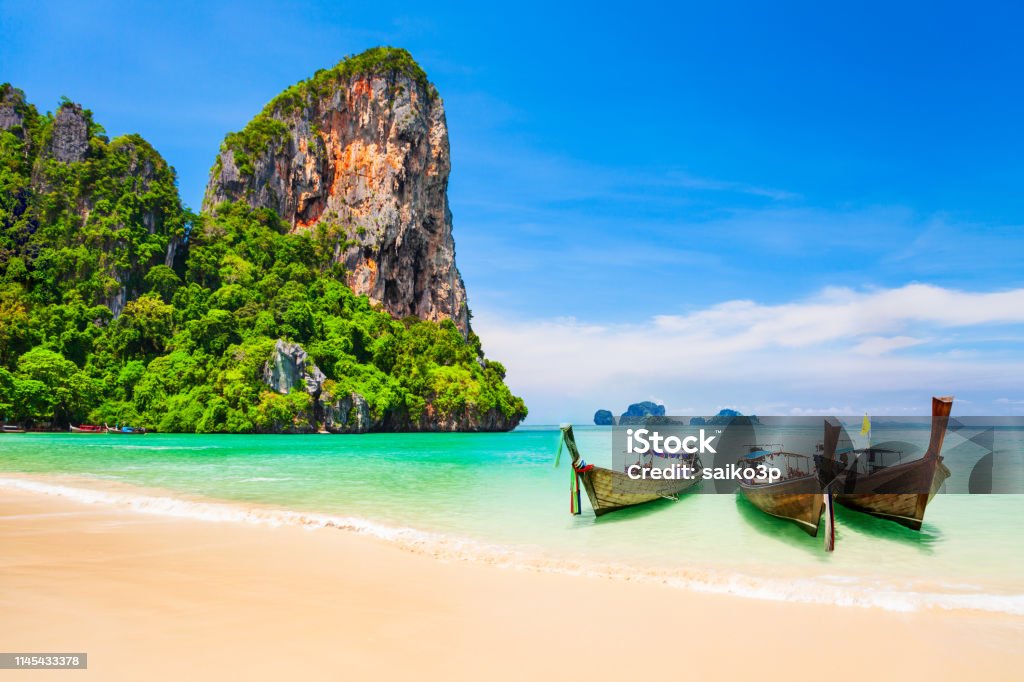 Clear water beach in Thailand Boats at the beauty beach with limestone cliff and crystal clear water in Thailand Thailand Stock Photo