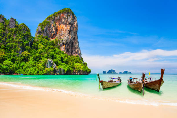 Clear water beach in Thailand Boats at the beauty beach with limestone cliff and crystal clear water in Thailand phi phi islands stock pictures, royalty-free photos & images