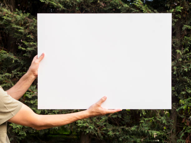 istock man holding up the poster,blank billboard.banner 1145438820