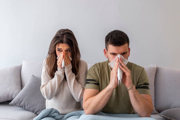 os pares doentes estão tentando espirrar no guardanapo - cold and flu flu virus bed couple - fotografias e filmes do acervo
