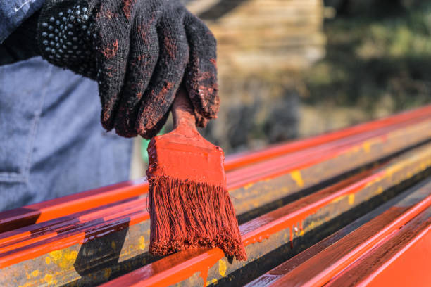 istock Worker painter covers protective paint metal structures. Protective coating of steel closed profiles with primer iron oxide red. 1145439122