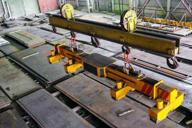 Overhead traveling crane with magnetic grippers traverse for lifting steel sheets. Industrial indoors area. stock photo
