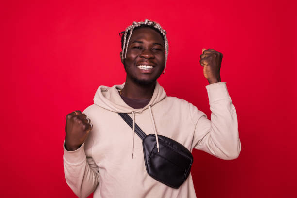 istock Young cool african man celebratin sign isolated on red background 1145447422