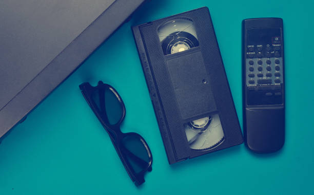 istock Vhs player, video cassette, 3d glasses, tv remote on a blue background. Obsolete media technologies. Top view. 1145448451