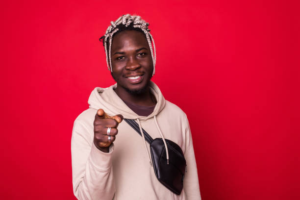 istock African man poiting at you, isolated over red background 1145448740