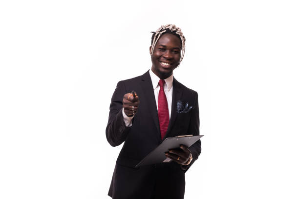 魅力的なスタンディングアフロアメリカのビジネスマンはノートを書いて、白い背景に孤立したカメラで微笑んで - looking at camera smiling desk isolated ストックフォトと画像