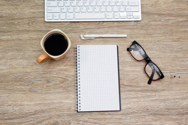 istock keyboard, coffee cup, hand watch, notebook and glasses on wooden table 1145454122