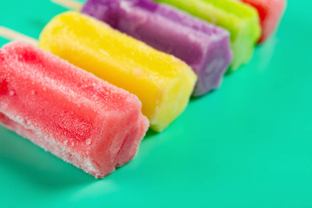 istock multi-color popsicles line up on green background with copy space 1145454647