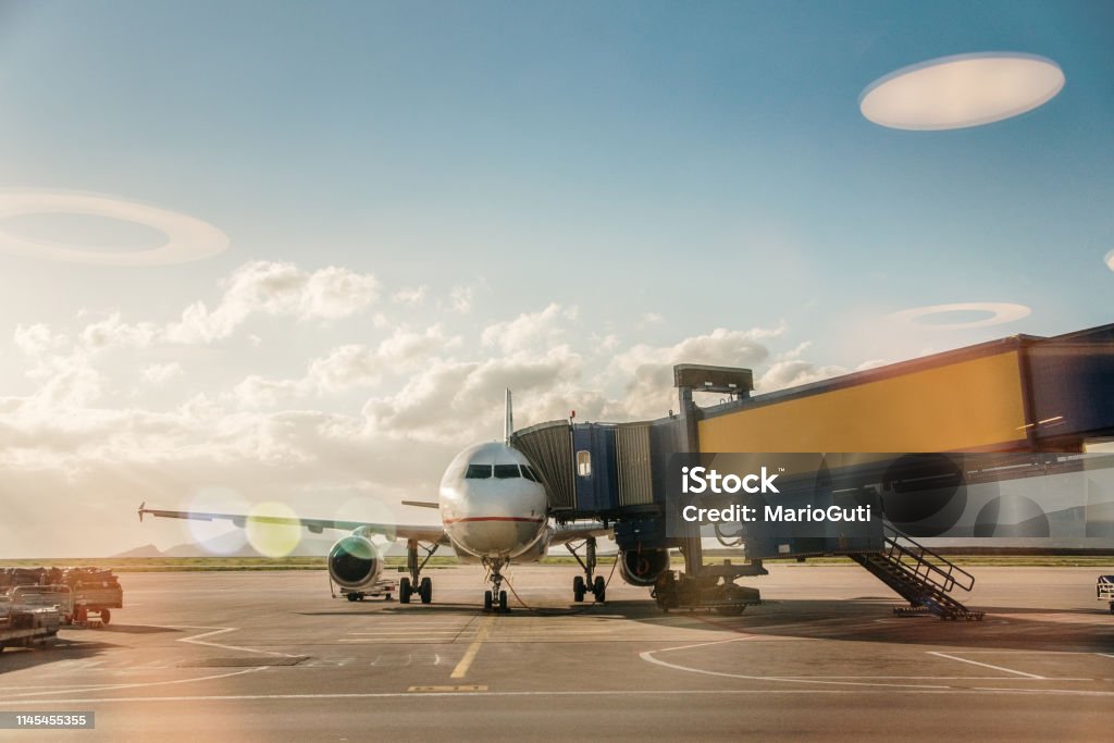 Airplane in an airport An airplane parked in an airport Passenger Boarding Bridge Stock Photo