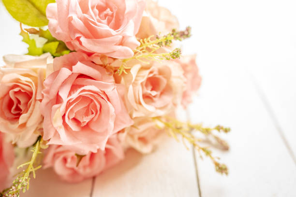 istock Pink roses on white wooden background 1145456146