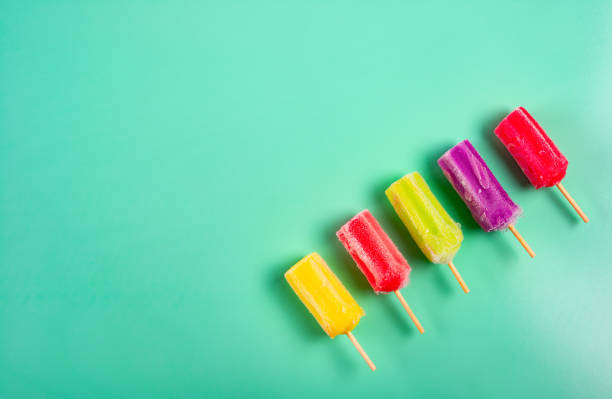istock multi-color popsicles line up on green background with copy space 1145456916