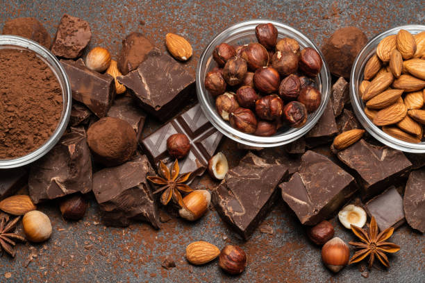 istock Heap of broken chocolate pieces and nuts on dark concrete background 1145459821