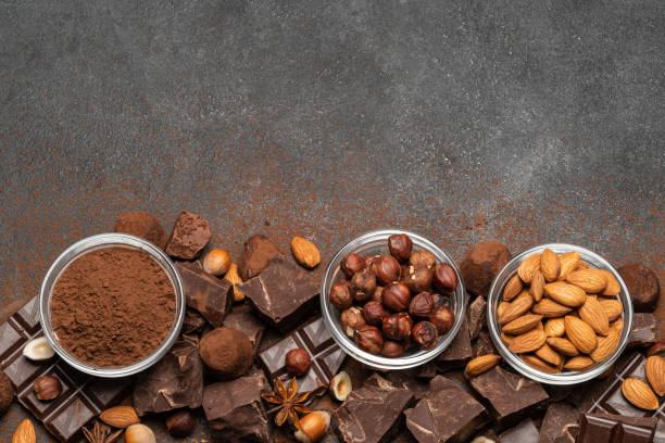 istock Heap of broken chocolate pieces and nuts on dark concrete background 1145459825