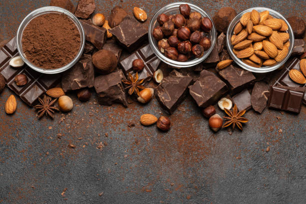istock Heap of broken chocolate pieces and nuts on dark concrete background 1145459832