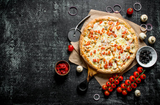 istock Hot pizza on paper with cherry tomatoes. 1145461518
