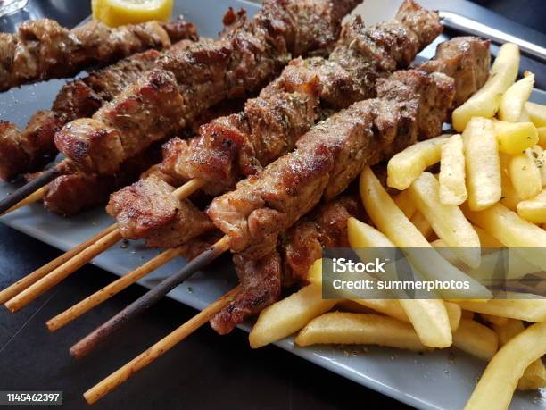 Souvlaki Greek Etnic Food Mear Roasted In A Plate Wiht Lemon And Potatoes Stock Photo - Download Image Now