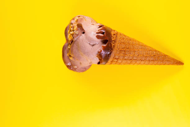 istock top view chocolate flavor ice cream cone in a melting process on yellow background 1145462852