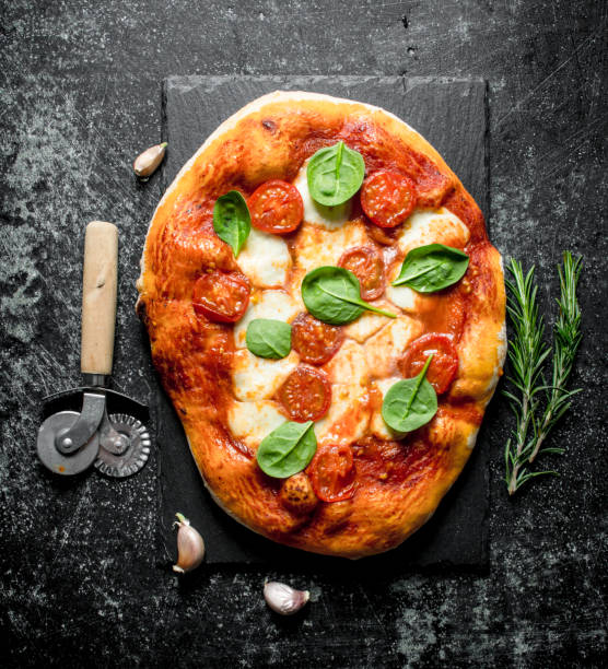 istock Homemade pizza with sausages, cheese and spinach. 1145463679