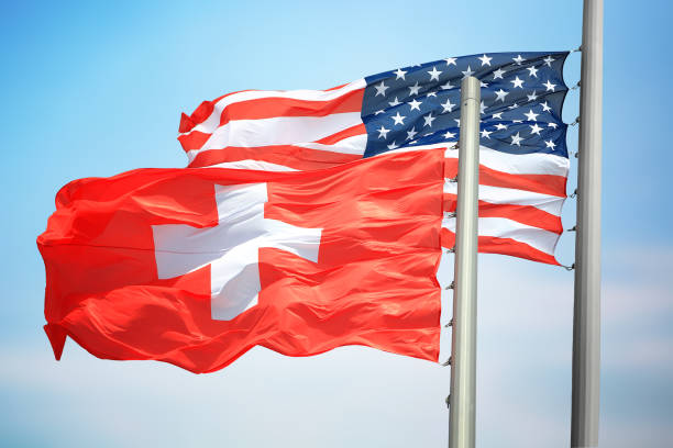 Flags of Switzerland and the USA against the background of the blue sky