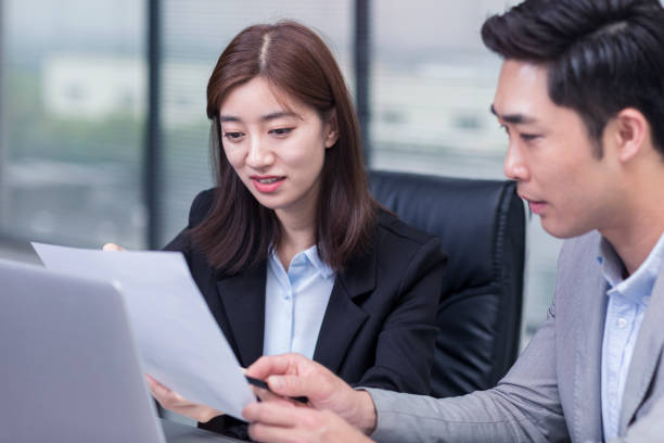 istock Business colleagues reviewing paperwork at office desk 1145466672