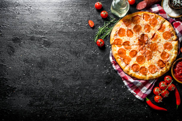 istock Pepperoni pizza on a napkin with chili and tomatoes. 1145469864