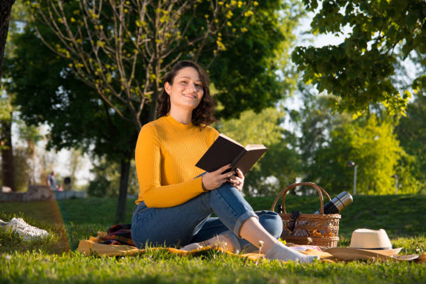 istock Relaxed woman reading a book on picnic in nature 1145470815