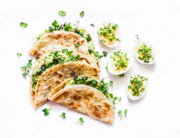 istock Avocado cream cheese micro greens quesadilla and boiled eggs on a light background, top view. Delicious healthy breakfast, snack, brunch. Flat lay 1145472867