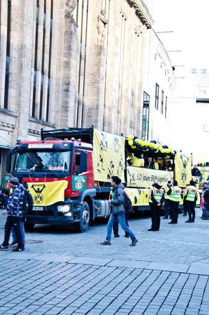 sicherheitspersonal, touristen und einheimische bei der dortmunder rosenmontag-parade in deutschland. - football police officer crowd stock-fotos und bilder